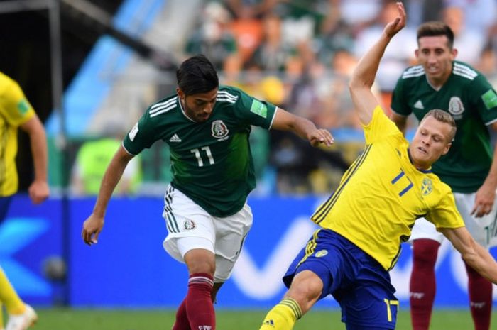 Gelandang serang Meksiko, Carlos Vela (kiri), berduel dengan Viktor Claesson dari Swedia dalam partai Piala Dunia 2018 di Ekaterinburg Arena, Ekaterinburg, 27 Juni 2018.