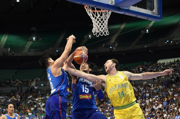Pemain timnas basket Australia, Angus Brandt (jersey kuning #14), berebut rebound dengan pemain Filipina,  June Fajardo (jersey biru, tengah) pada laga kualifkasi kejuaraan dunia FIBA di Bocaue town, Bulacan, Filipina, 2 Juli 2018. Australia menang dengan skor 89-53.