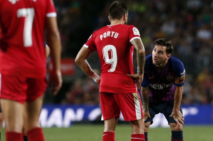 Ekspresi penyerang Barcelona, Lionel Messi (kanan), saat berbincang dengan gelandang Girona, Cristian Portugues alias Portu, pada laga Liga Spanyol 2018-2019 di Stadion Camp Nou, Barcelona, Spanyol, pada Minggu (23/9/2018).