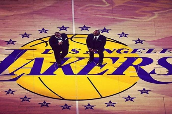 Dua legenda Los Angeles Lakers, Magic Johnson (kiri) dan Kobe Bryant (kanan) berdiri berdampingan di tengah acara pemensiunan dua nomor punggung milik Kobe Bryant, Senin (18/12/2017) malam waktu Amerika Serikat atau Selasa siang WIB.