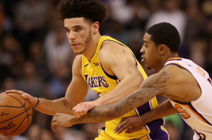 Pebasket rookie Los Angeles Lakers, Lonzo Ball (jersey kuning, #2), mendribel bola seraya dijaga oleh pemain Phoenix Suns pada laga musim reguler NBA 2017-2018 yang berlangsung di Talking Stick Resort Arena, Phoenix, Arizona, Senin (13/11/2017).