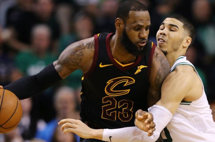 Pebasket megabintang Cleveland Cavaliers, LeBron James (jersey hitam, #23), berupaya melewati penjagaan pemain Boston Celtics, Jayson Tatum, pada laga gim ketujuh final Wilayah Timur NBA 2018 yang berlangsung di TD Garden, Boston, Massachusetts, Amerika Serikat, Senin (28/5/2018).