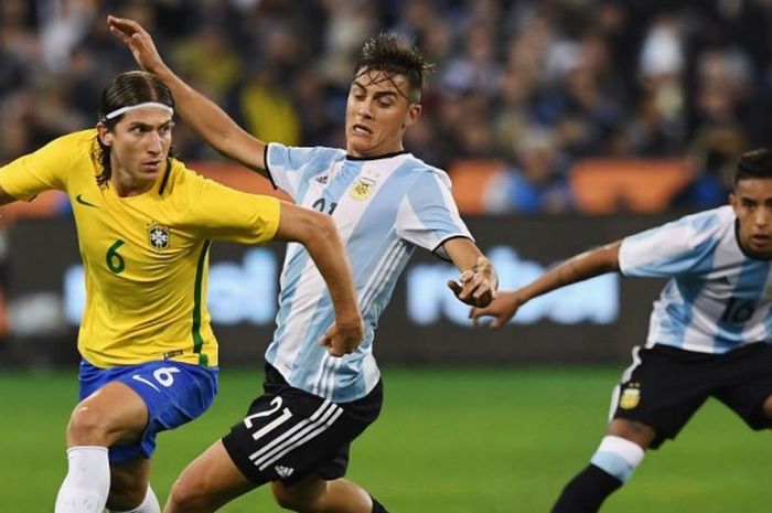 Striker Argentina, Paulo Dybala (tengah), berusaha merebut bola dari bek kiri Brasil, Filipe Luis, dalam laga persahabatan di Stadion Melbourne Cricket Ground, Melbourne, Australia, pada 9 Juni 2017.