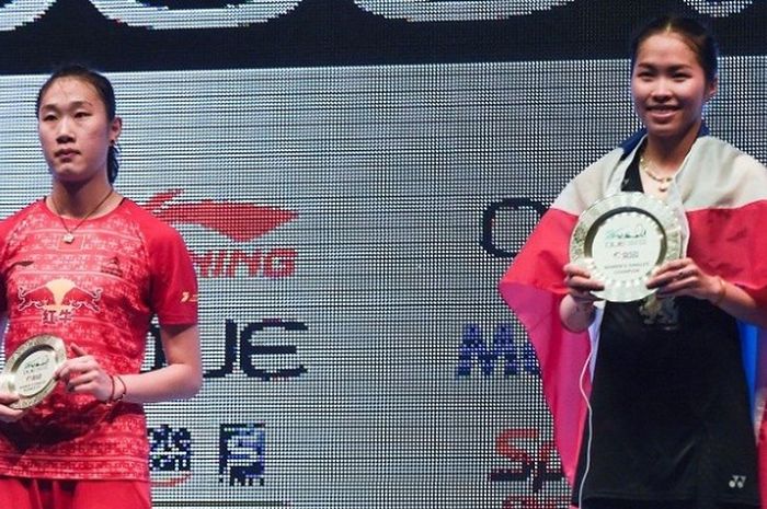 Pebulu tangkis tunggal putri Thailand, Ratchanok Intanon (kanan), berpose dengan trofi juara Singapura Terbuka setelah mengalahkan Sun Yu (China), 18-21, 21-11, 21-14 di Singapore Indoor Stadium, Minggu (17/4/2016).