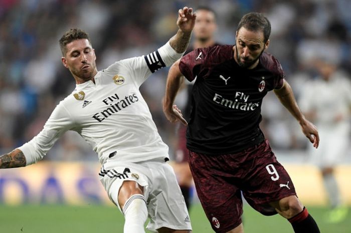 Penyerang AC Milan, Gonzalo Higuain (kanan), berduel dengan bek Real Madrid, Sergio Ramos, dalam laga Trofeo Santiago Bernabeu di Stadion Santiago Bernabeu, Madrid, Spanyol pada 11 Agustus 2018.