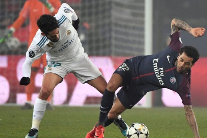 Gelandang Real Madrid, Isco (kiri), berduel dengan bek kanan Paris Saint-Germain, Dani Alves, dalam laga leg kedua babak 16 besar Liga Champions di Stadion Parc des Princes, Paris, Prancis, pada 6 Maret 2018.