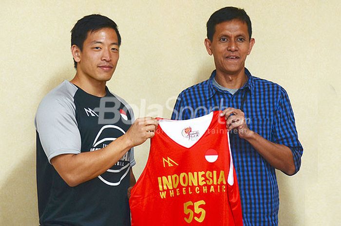 Pebasket Donald Santoso memberikan Jersey Basket kepada Redaktur Pelaksana Tabloid BOLA, Riemantono Harsojo sebagai ucapan terimakasih dari Tim Basket Kursi Roda dalam Media Visit Ke Kompas Gramedia Group di Kantor Redaksi Tabloid Bola, Jakarta. Selasa (18/9/2018).