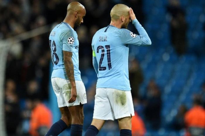 Pemain Manchester City, David Silva (kanan) dan Fabian Delph, meninggalkan lapangan dengan lesu setelah dikalahkan Olympique Lyon dalam partai Liga Champions di Stadion Etihad, Manchester, 19 September 2018.