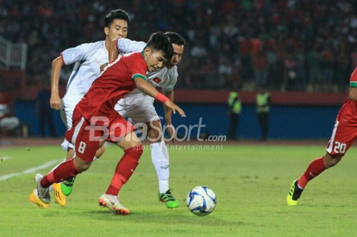  Pemain bertahan timnas U-19 Vietnam mencoba menahan laju penyerang timnas U-19 Indonesia, Witan Sulaiman pada laga fase Grup A Piala AFF U-19 2018 di Stadion Gelora Delta, Sidoarjo, 7 Juli 2018.  