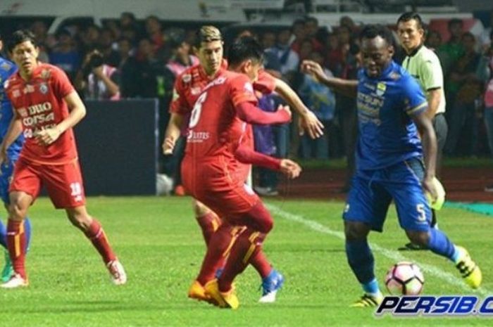 Gelandang Persib Bandung, Michael Essien, menguasai bola dengan dibayangi pemain Arema saat kedua tim bertemu pada pertandingan Liga 1, Sabtu (15/4/2017).