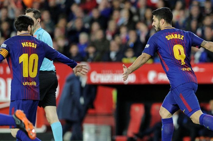 Striker FC Barcelona, Luis Suarez (kanan), merayakan gol bersama Lionel Messi dalam laga Liga Spanyol kontra Sevilla di Stadion Ramon Sanchez Pizjuan, Sevilla pada 31 Maret 2018.