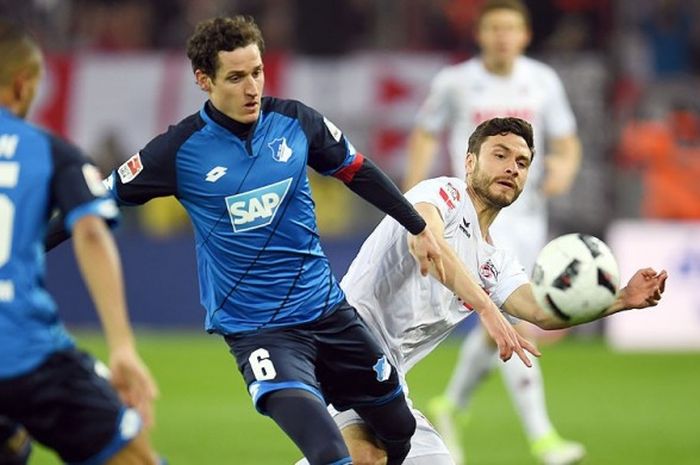 Gelandang Hoffenheim, Sebastian Rudy, berupaya menendang bola namun diganjal bek Koeln, Jonas Hector, dalam laga lanjutan Liga Jerman 2016-2017 di Koeln, (21/4/2017).