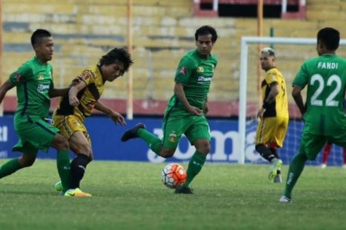 Gelandang Mitra Kukar, Asri Akbar di antara tiga pemain Bhayangkara FC di Stadion Gelora Delta, Sidoarjo, Minggu (11/6/2016).