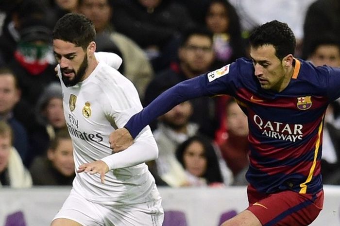 Isco (kiri) dan Sergio Busquets berduel saat Real Madrid bertemu Barcelona pada lanjutan La Liga di Stadion Santiago Bernabeu, Sabtu (21/11/2015). 