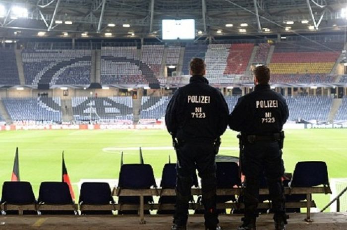 Dua petugas kepolisian berjaga di Stadion HDI Arena, Selasa (17/11/2015), setelah laga persahabatan antara Jerman dan Belanda dibatalkan karena alasan keamanan 