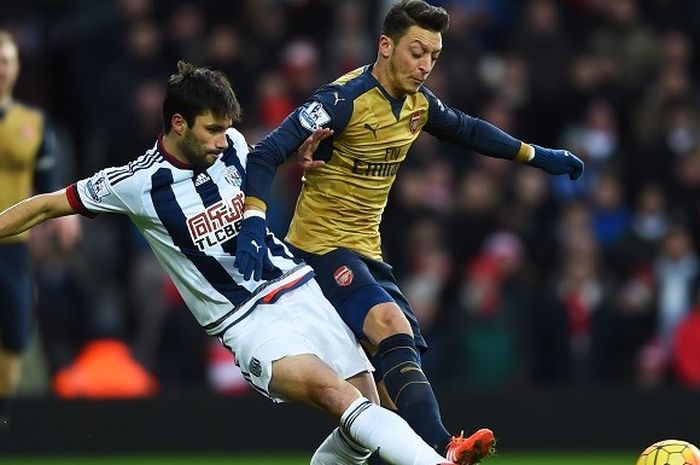 Gelandang Arsenal, Mesut Oezil, berduel dengan gelandang West Bromwich Albion, Claudio Yacob, pada laga Premier League di Stadion The Hawthorns, Sabtu (21/11/2015).