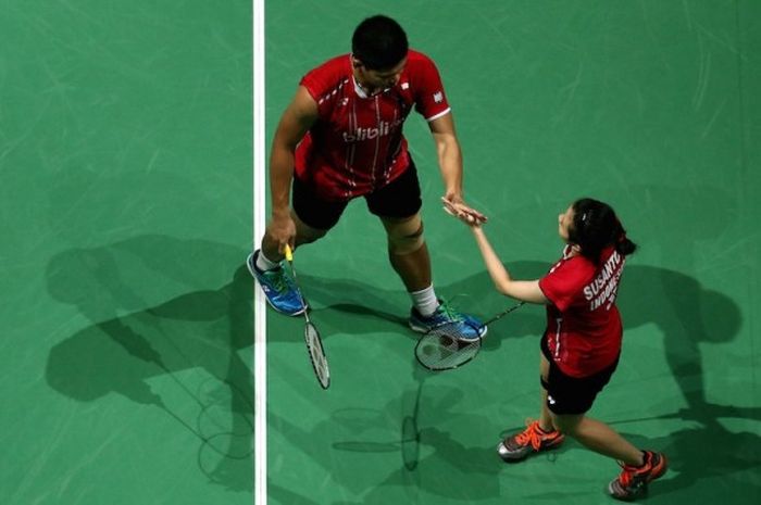 Pasangan ganda campuran Indonesia, Praveen Jordan/Debby Susanto, melakukan tos setelah meraih poin saat menghadapi Joachim Fischer Nielsen/Christinna Pedersen (Denmark) pada babak penyisihan grup BWF Superseries Finals di Hamdan Sports Complex, Jumat (11/12/2015), Jumat (11/12/2015).