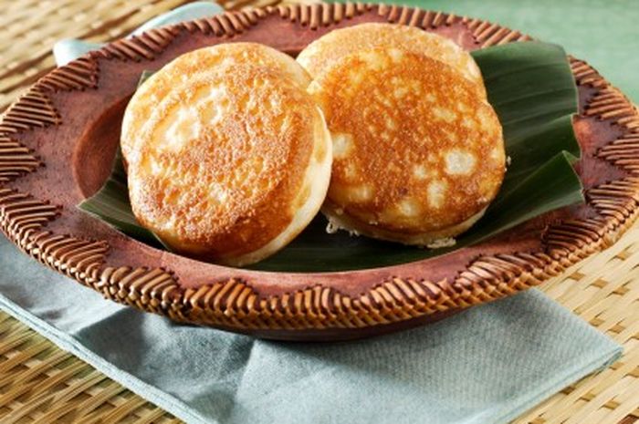 Kue Apen Bersarang Tradisional: Sepiring Kue Apen Bersarang dengan tekstur berongga dan warna kecokelatan yang menggoda, siap disajikan sebagai camilan manis yang lezat