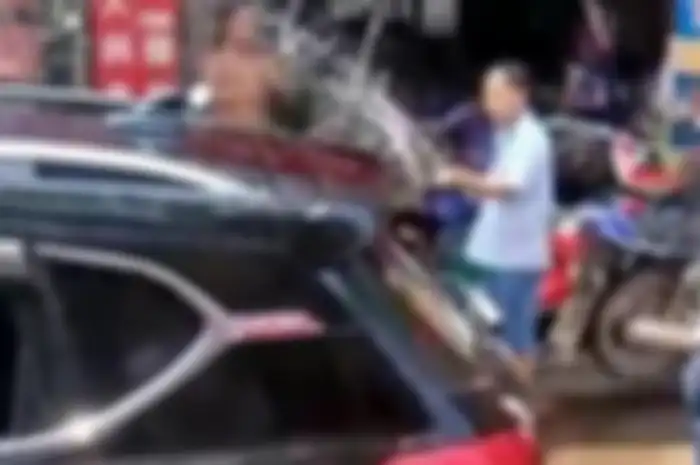 Seorang anak terkunci di dalam mobil, orang tuanya tak ingin kaca mobilnya dipecah untuk mengeluarkannya, warga pun membantu menyemprotkan air. 