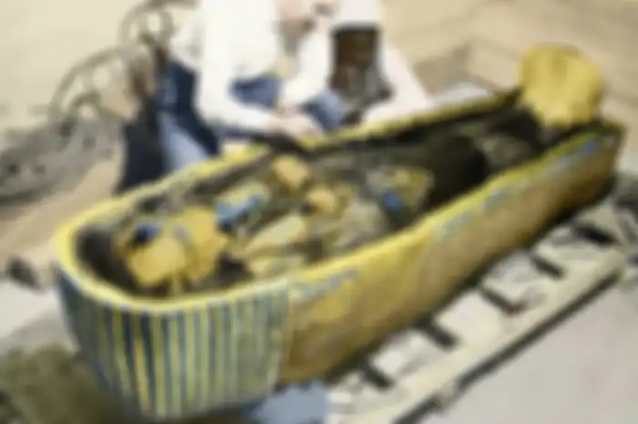 Mayat mumi Firaun Tutankhamun dikelilingi oleh barang kuburan berharga, di peti emasnya, setelah ruang pemakamannya secara resmi dibuka pada 1923.