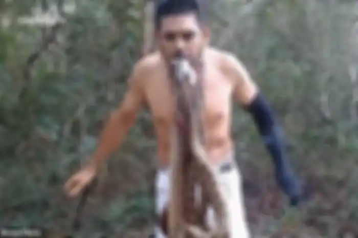 Seorang pria  melakukan aksi nekat dengan menggantungkan ular berbisa di dalam mulutnya, tujuanya ternyata mulia.