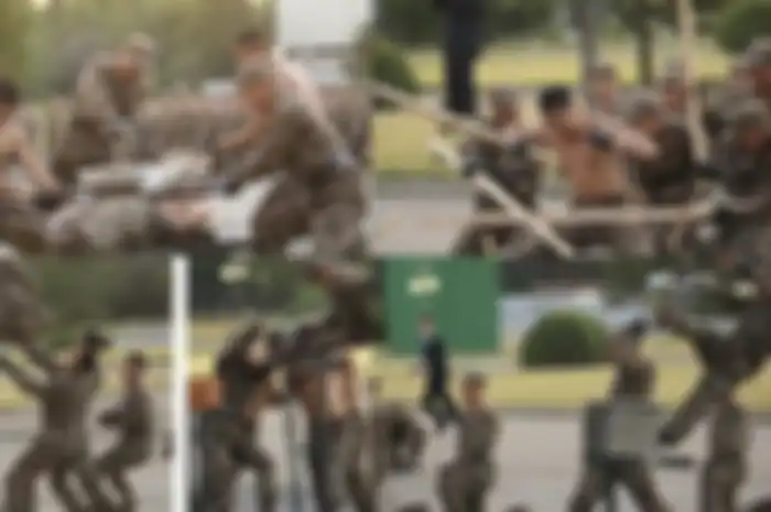 Para tentara Korea tentara terlihat bertelanjang dada sambil memecahkan dua botol kaca bersama-sama saat Kim Jong Un lewat.