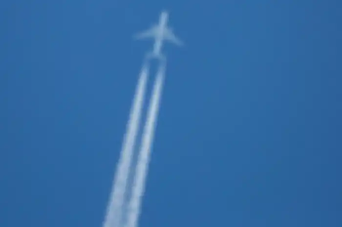 Ilustrasi jejak contrail dari pesawat yang melintas