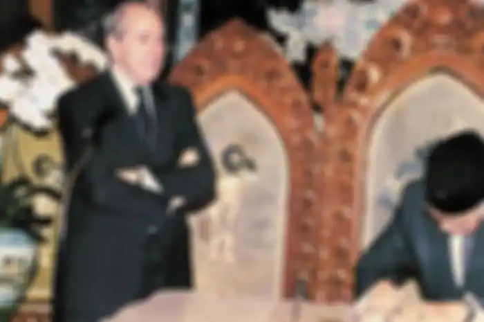 Direktur Pelaksana IMF Michel Camdessus menyaksikan Presiden Soeharto menandatangani nota kesepakatan bantuan Dana Moneter Internasional di Jalan Cendana. Artikel ini menjelaskan mengapa krisis keuangan yang berawal di Thailand dapat berpengaruh terhadap Indonesia pada tahun 1997-1998. Baca selengkapnya di sini.