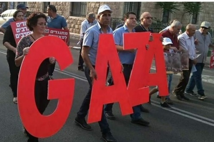 Partai Komunis Israel mengibarkan bendera Palestina, juga simbol-simbol berwarna merah yang ditulis baik dalam bahasa Arab maupun Ibrani.