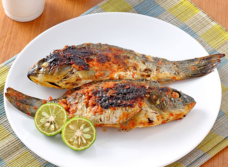 Ikan mas bakar dengan bumbu rempah kaya rasa, disajikan hangat bersama sambal dan lalapan segar