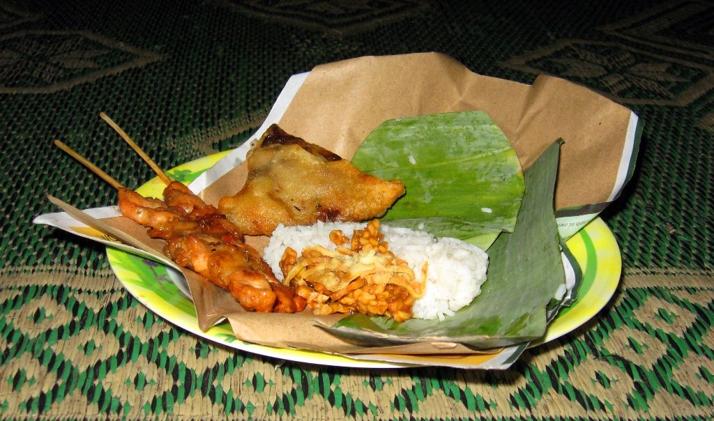 Nasi kentut khas Sumatra Utara dengan daun kentut, lauk ayam bakar, tahu goreng, dan sambal terasi, disajikan hangat