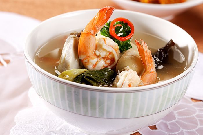 Semangkuk sup udang jamur merang yang hangat dengan kuah bening, potongan wortel, dan udang segar