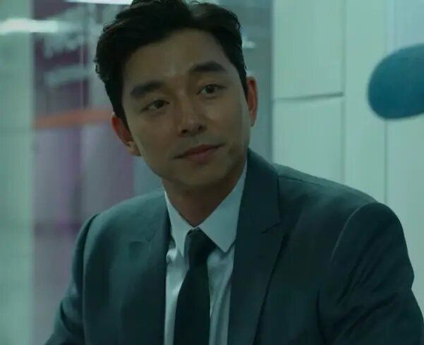 Perekrut &mdash; seorang pria berjas  yang diperankan oleh Gong Yoo &mdash; duduk di stasiun kereta sambil memandangi Gi-hun 