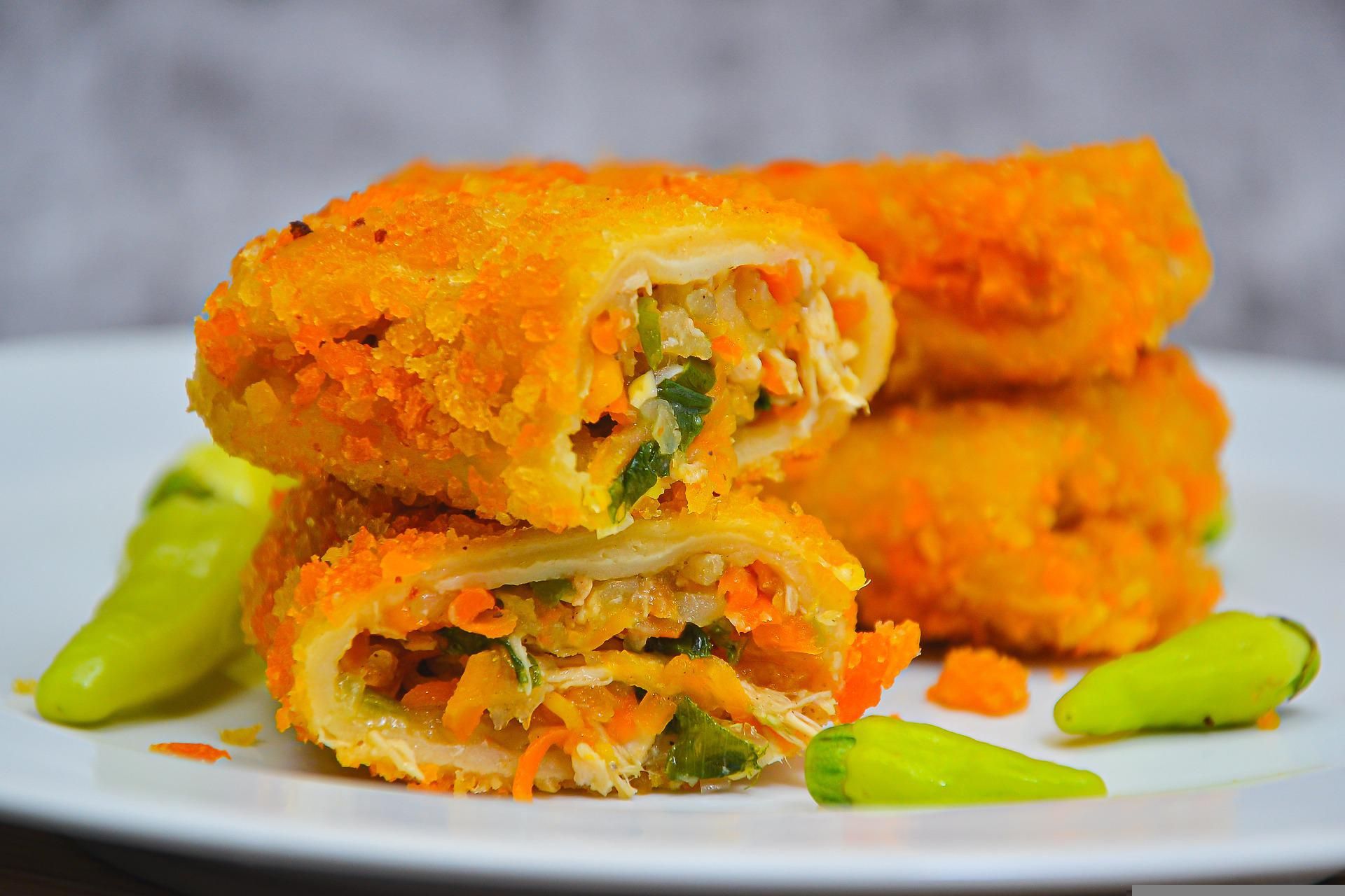 Kulit Risoles Renyah: Risoles dengan kulit tipis dan renyah, berisi daging cincang dan sayuran segar, disajikan dengan saus pedas sebagai pendamping