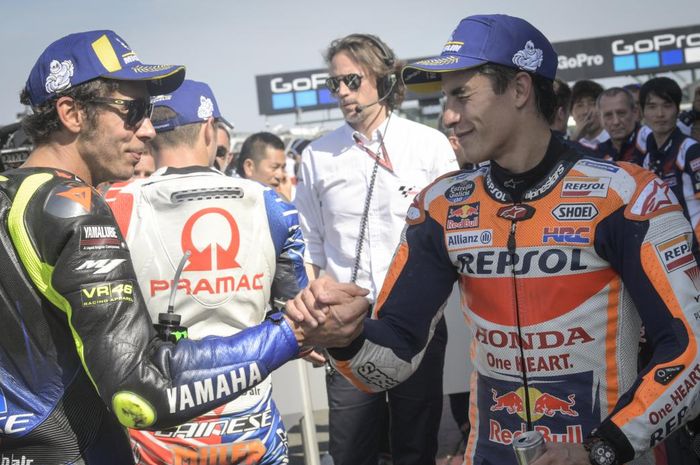 Dua pembalap MotoGP, Valetino Rossi (kiri), dan Marc Marquez (kanan) tengah berjabat tangan. 