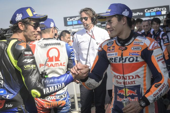 Valentino Rossi dan Marc Marquez berjabat tangan setelah kualifikasi MotoGP Inggris di Sirkuit Silverstone, Inggris, 24 Agustus 2019.