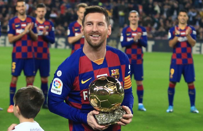Bintang FC Barcelona, Lionel Messi, berpose dengan trofi Ballon d'Or. Messi memutuskan bertahan di Barcelona untuk musim 2020-2021.