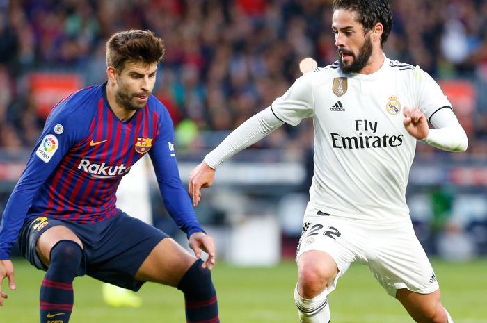 Pemain Real Madrid, Isco, berusaha melewati bek Barcelona, Gerard Pique, pada laga El Clasico, Oktober 2018.