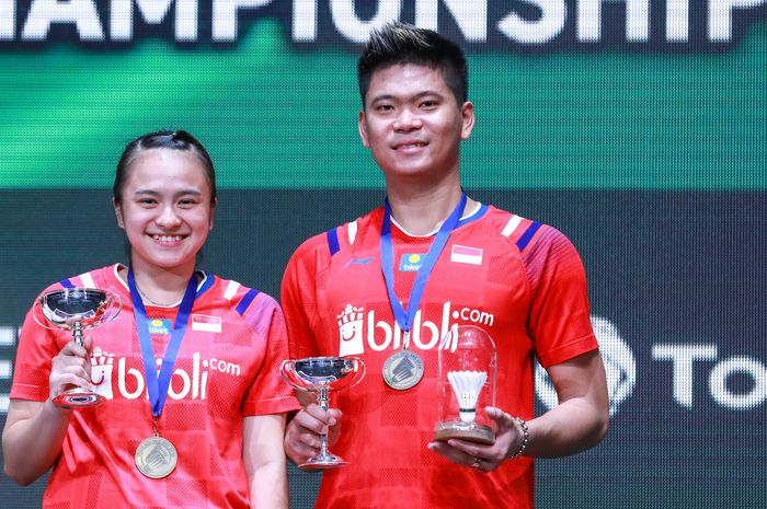 Pasangan ganda campuran Indonesia, Praveen Jordan (kanan)/Melati Daeva Oktavianti, berpose di atas podium kampiun All England Open 2020, di Arena Birmingham, Inggris, Minggu (15/3/2020).