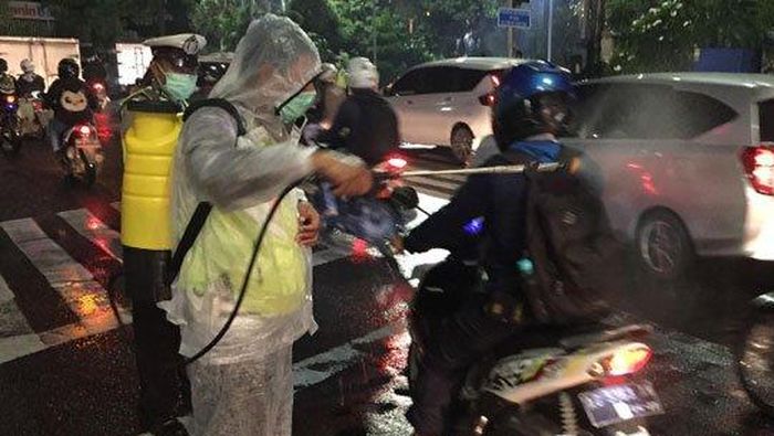 Polsek Wonokromo Surabaya lakukan penyemprotan disinfektan pada pengguna jalan di Jalan Darmo Surabaya, Jumat (27/3/2020) malam WIB.