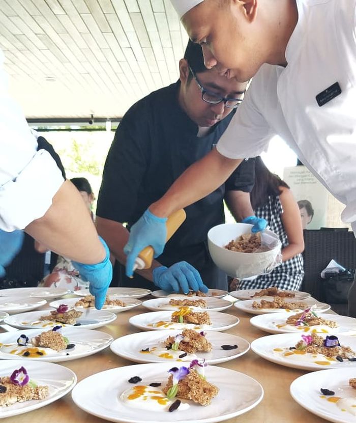 Chef Bayu Prasetyo bersama timnya tengah menghias makanan menggunakan edible flower