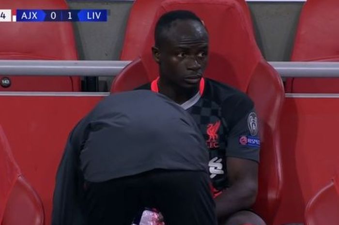 Pemain Liverpool, Sadio Mane, terlihat murung di bangku cadangan sambil menggunakan kantong es di kakinya setelah ditarik keluar pada menit 60 di laga melawan Ajax di penyisihan grup Liga Champions 2020/2021, Kamis (22/10/2020), di Stadion Johan Cruyff, Amsterdam.