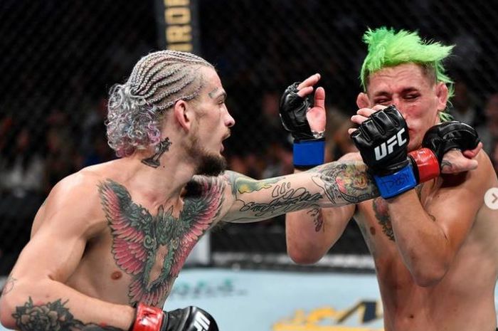 Sean O'Malley (kiri) tengah melepaskan pukulan buasnya ke arah Kris Motinho (kanan) pada UFC 264 Minggu (11/7/2021).