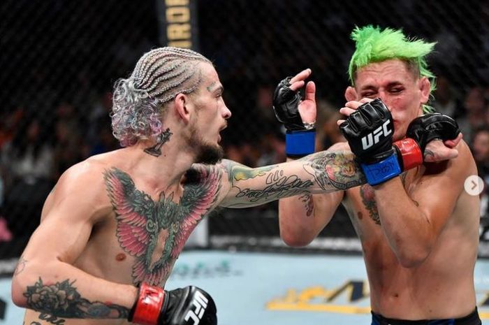 Bintang baru, Sean O'Malley (kiri) tengah melepaskan pukulan buasnya ke arah Kris Motinho (kanan) pada UFC 264 Minggu (11/7/2021).