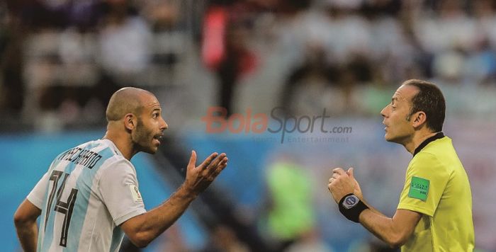  Gelandang Argentina, Javier Mascherano (kiri), berbicara kepada wasit Cuneyt Cakir saat membela timnas Argentina.