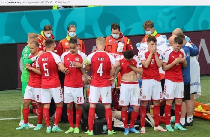 Para pemain timnas Denmark mengelilingi Christian Eriksen yang sedang menerima perawatan.