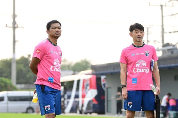 Berdiri di samping Issara Sritaro, Masatada Ishii (kanan) sering hadir dalam sesi latihan Timnas U-23 Thailand.