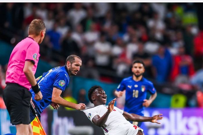 Bek timnas Italia, Giorgio Chiellini, melanggar winger timnas Inggris, Bukayo Saka, dalam laga final EURO 2020 di Stadion Wembley, Minggu (11/7/2021).