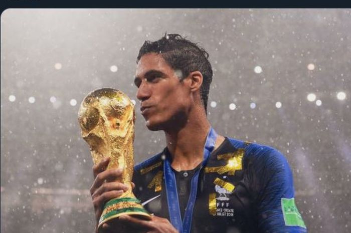 Raphael Varane mencium trofi Piala Dunia 2018 setelah juara bersama timnas Prancis.