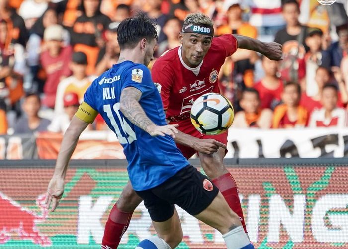 Pemain PSM Makassar mencoba menghalau tendangan pemain Persija Jakarta, Bruno Matos di Stadion Utama Gelora Bung Karno (SUGBK), Minggu (21/7/2019).